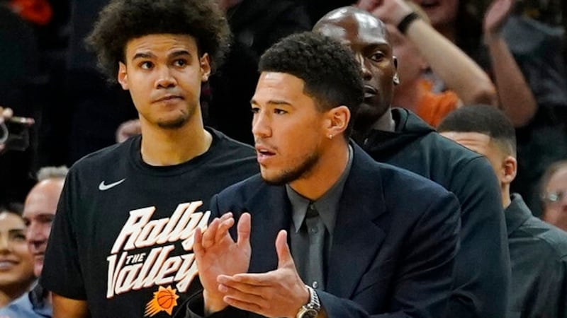 Phoenix Suns guard Devin Booker watches from the bench during the first half of Game 5 of an...
