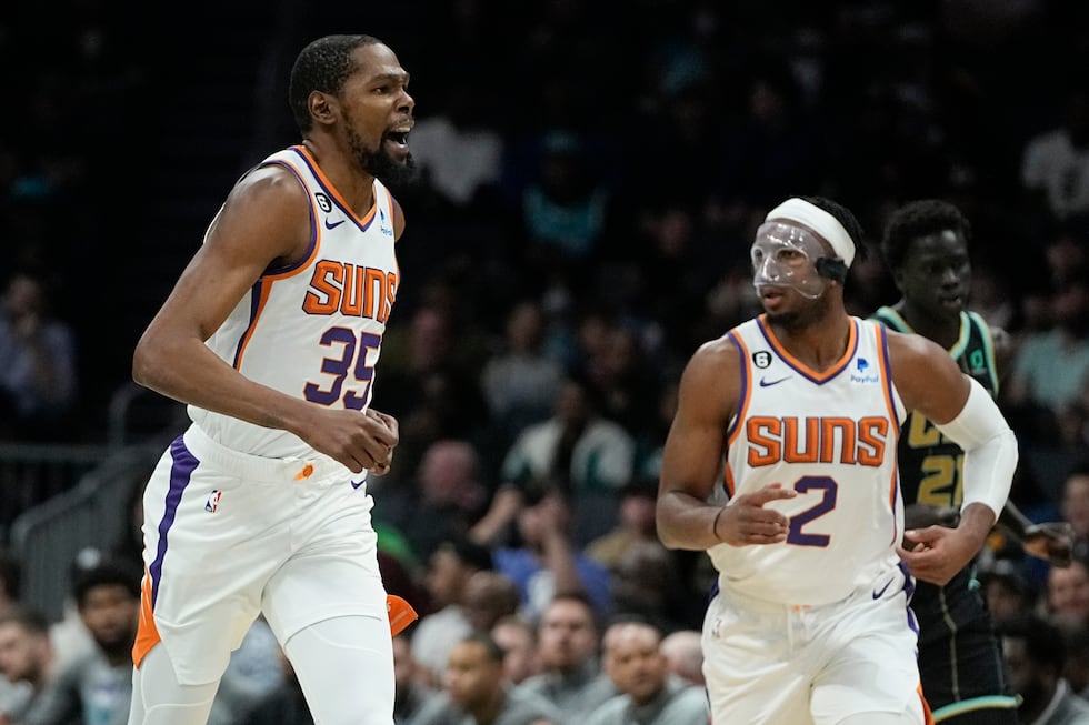 Phoenix Suns forward Kevin Durant celebrates after scoring as forward Josh Okogie looks on...