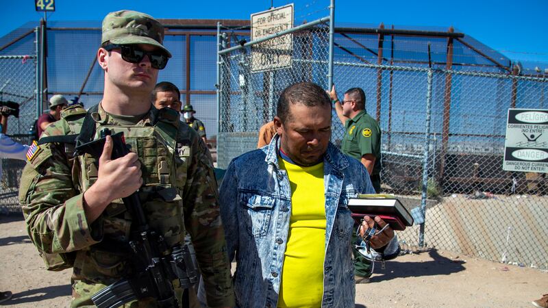 FILE - Migrants are escorted by a U.S. Army soldier after entering into El Paso, Texas from...