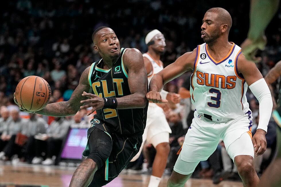 Charlotte Hornets guard Terry Rozier drives to the basket past Phoenix Suns guard Chris Paul...