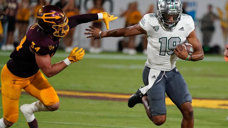 Eastern Michigan quarterback Austin Smith (19) runs away from Arizona State's Kyle Soelle (34)...