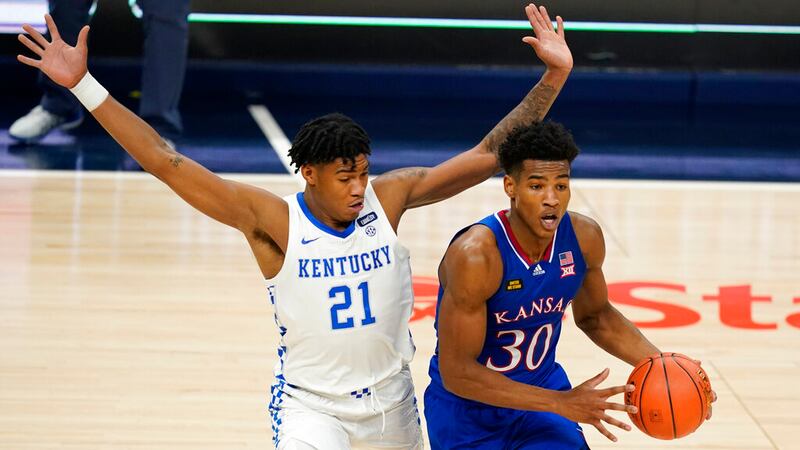 Kansas' Ochai Agbaji (30) is defended by Kentucky's Cam'Ron Fletcher (21) during the first...