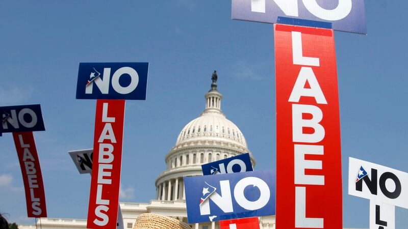 FILE - People with the group No Labels hold signs during a rally on Capitol Hill in...