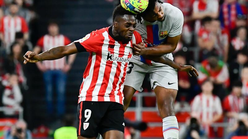 Athletic Bilbao's Inaki Williams, left, jumps for a header with Barcelona's Jules Kounde...