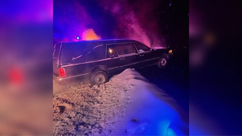 Investigators said the hearse slid off the interstate and came to a rest teetering off the...