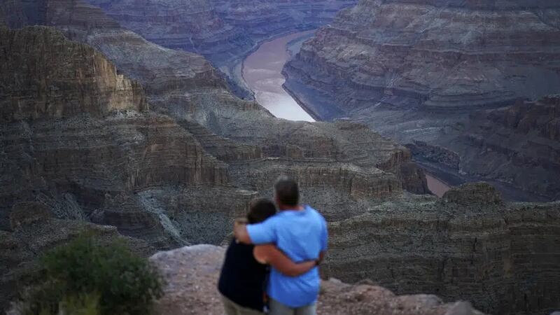 FILE - Alyssa Chubbuck, left, and Dan Bennett embrace while watching the sunset at Guano Point...
