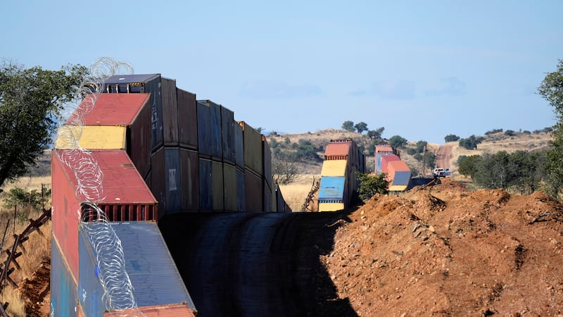 A long row of double-stacked shipping containers temporarily provided a new wall between the...