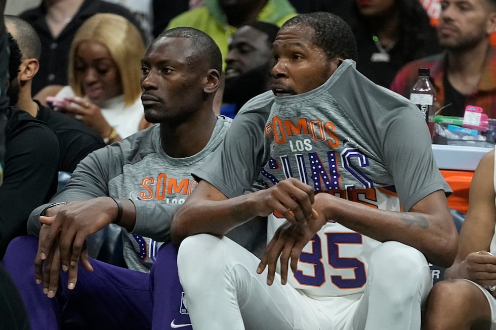 Phoenix Suns forward Kevin Durant watches during the first half of an NBA basketball game...