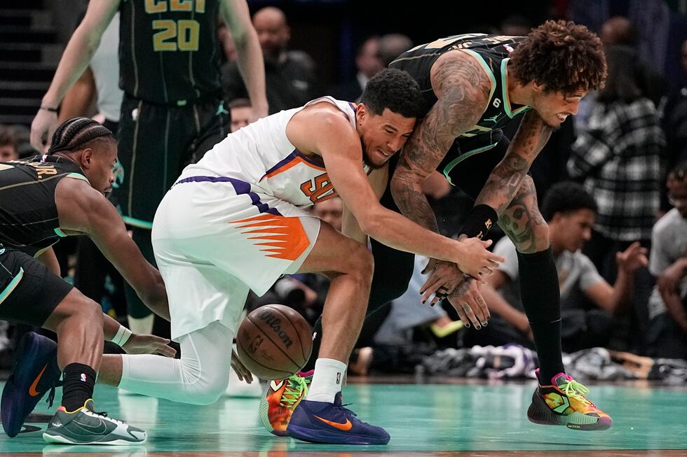 Charlotte Hornets guard Kelly Oubre Jr., right, and Phoenix Suns guard Devin Booker battles...